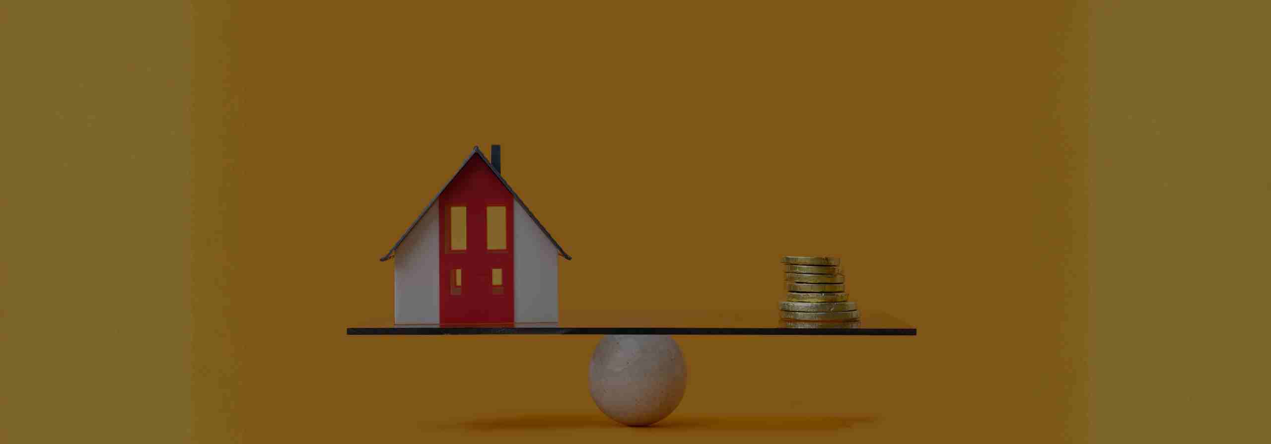 A little Scottsdale home and coins balanced on a small ball.